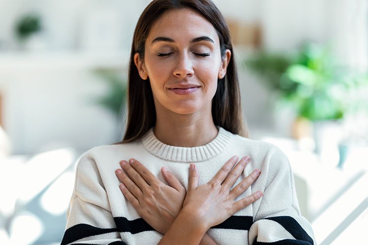 Mujer relajada, con sus manos sobre el pecho